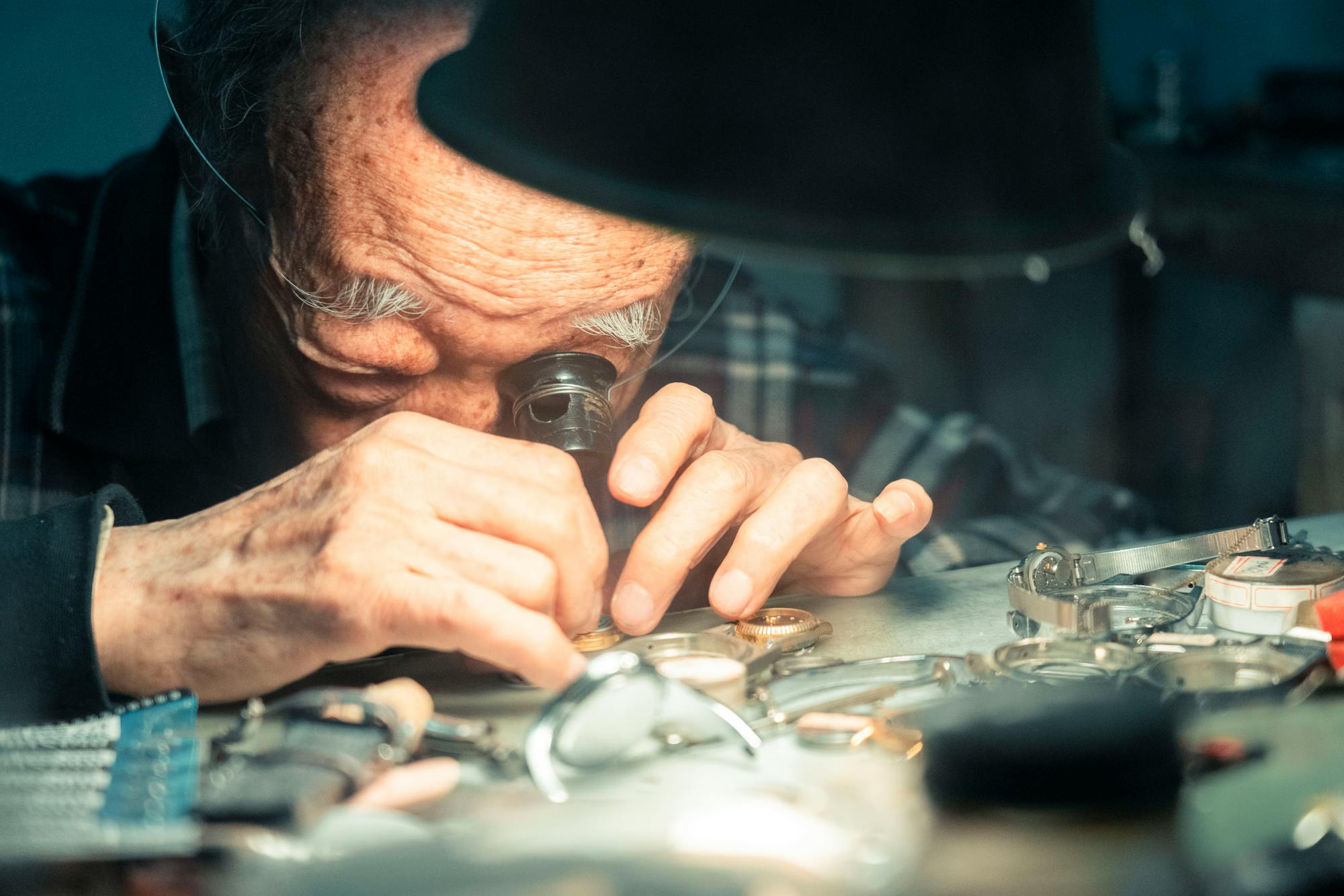 Orologiaio al lavoro con lente d'ingrandimento